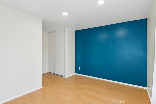 unfurnished room featuring recessed lighting, baseboards, and wood finished floors