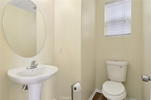 bathroom with toilet and baseboards