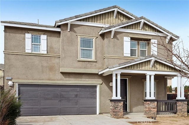 craftsman-style home with covered porch, stucco siding, driveway, and a garage