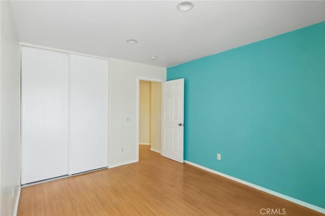 empty room featuring wood finished floors and baseboards