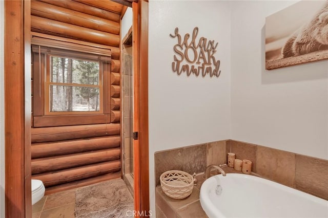 full bath featuring a shower stall, tile patterned floors, toilet, a garden tub, and rustic walls