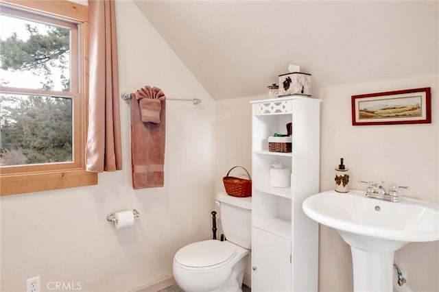 half bathroom with lofted ceiling and toilet