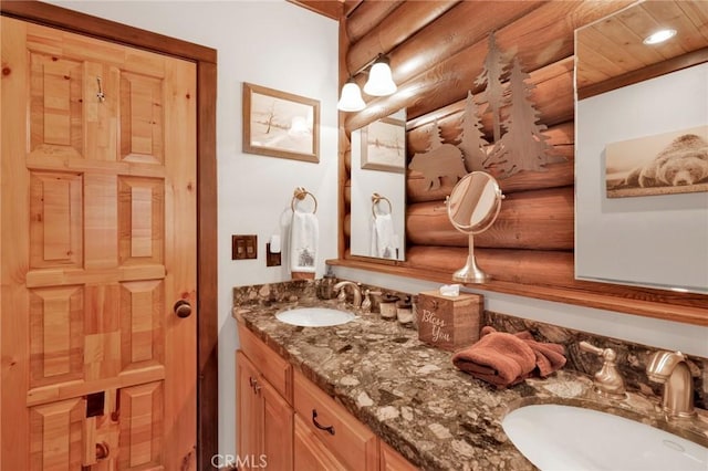 bathroom featuring a sink, log walls, and double vanity