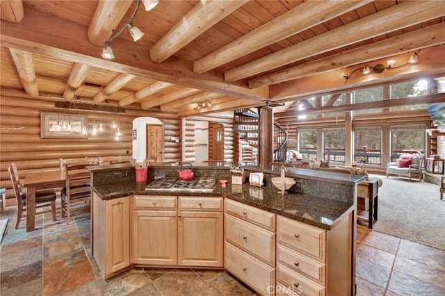 kitchen featuring beam ceiling, light brown cabinetry, open floor plan, wooden ceiling, and log walls