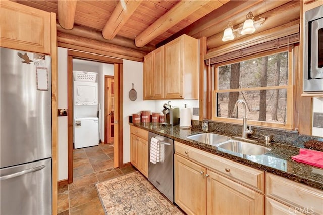 kitchen with a sink, stacked washing maching and dryer, light brown cabinetry, and stainless steel appliances