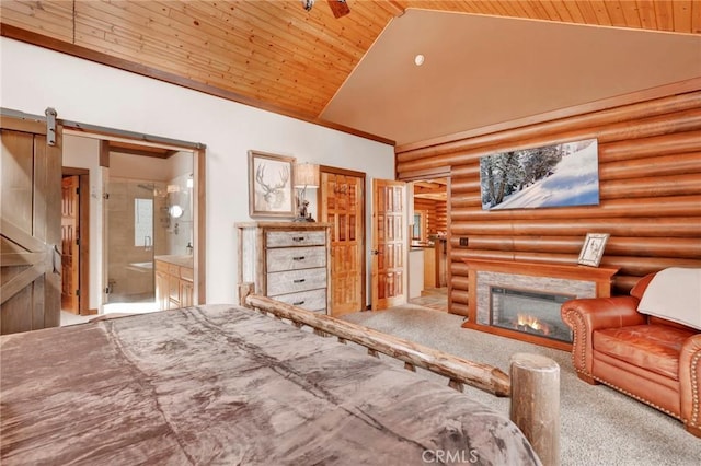 unfurnished bedroom featuring high vaulted ceiling, ensuite bath, a lit fireplace, wood ceiling, and a barn door