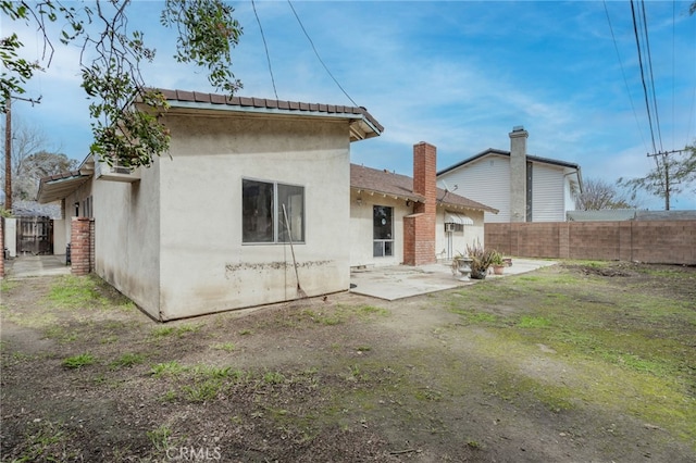 rear view of property with a patio area, stucco siding, and fence