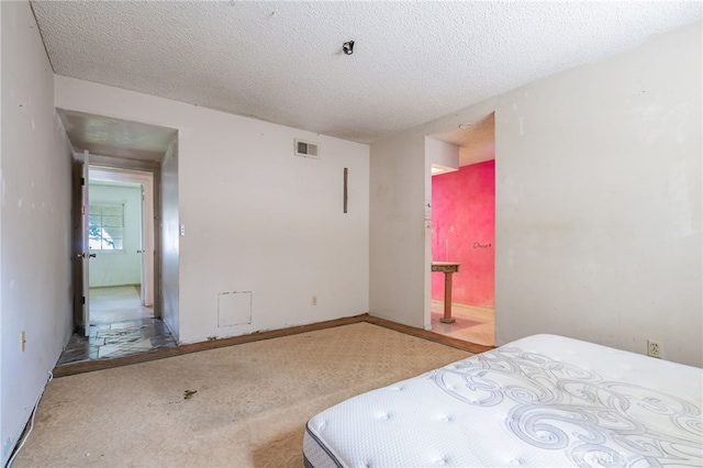 carpeted bedroom featuring visible vents and a textured ceiling