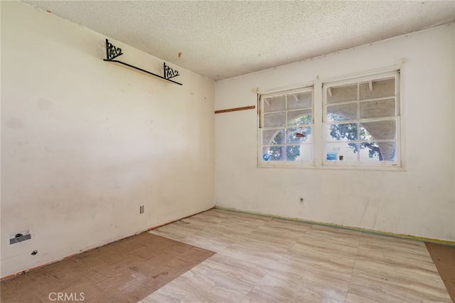 empty room featuring a textured ceiling and light floors