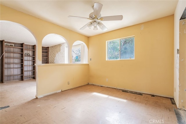 empty room with tile patterned floors and a ceiling fan