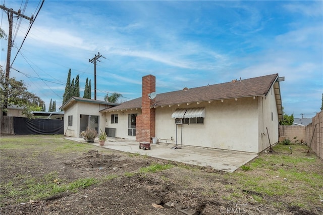 back of house with an outdoor fire pit, stucco siding, a chimney, a fenced backyard, and a patio area