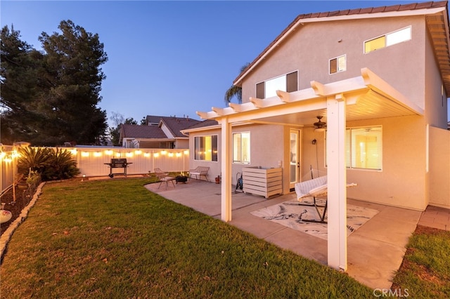 rear view of property with a patio, a yard, a fenced backyard, and stucco siding