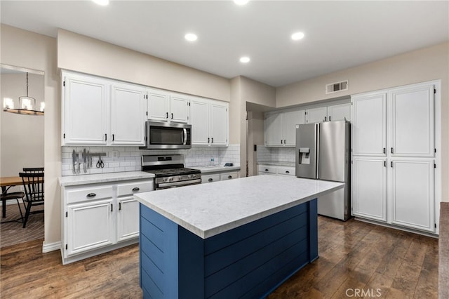 kitchen with dark wood-style floors, visible vents, white cabinets, and stainless steel appliances