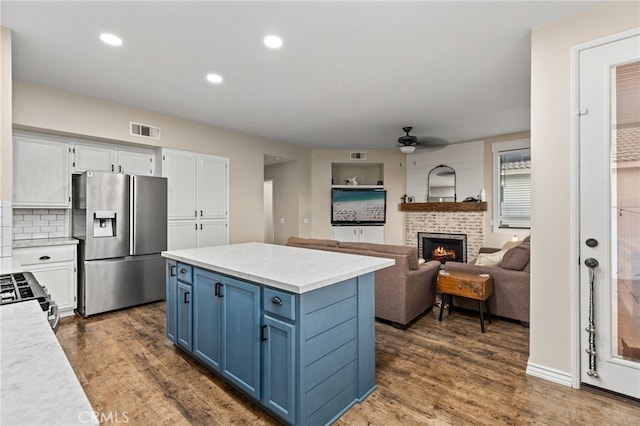 kitchen featuring visible vents, blue cabinetry, dark wood finished floors, white cabinets, and stainless steel appliances