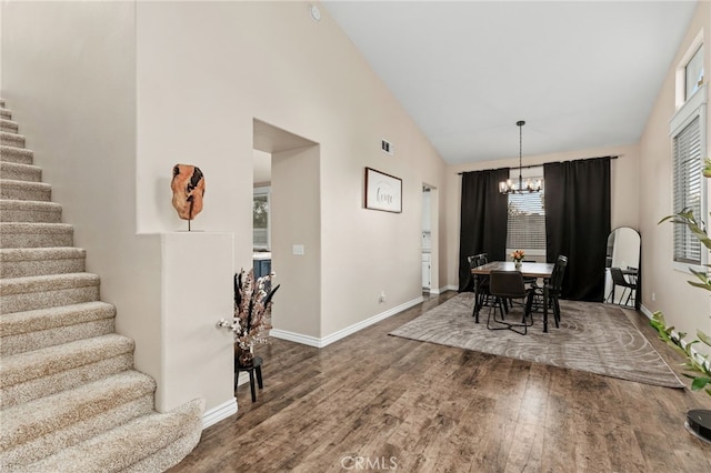 dining space with stairway, wood finished floors, visible vents, and a chandelier