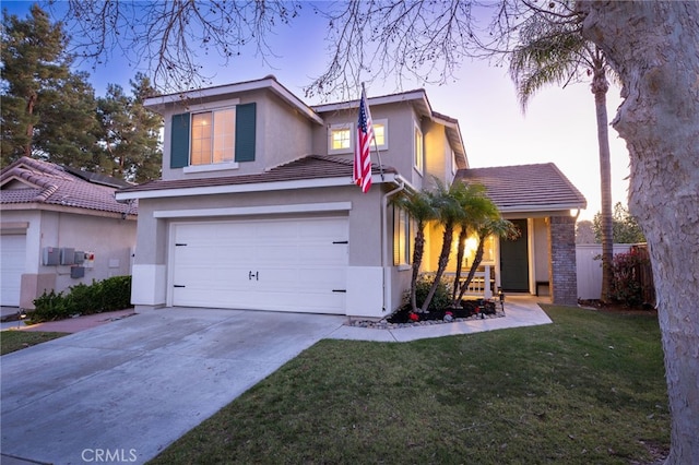 traditional-style home featuring stucco siding, driveway, a tile roof, a front yard, and a garage