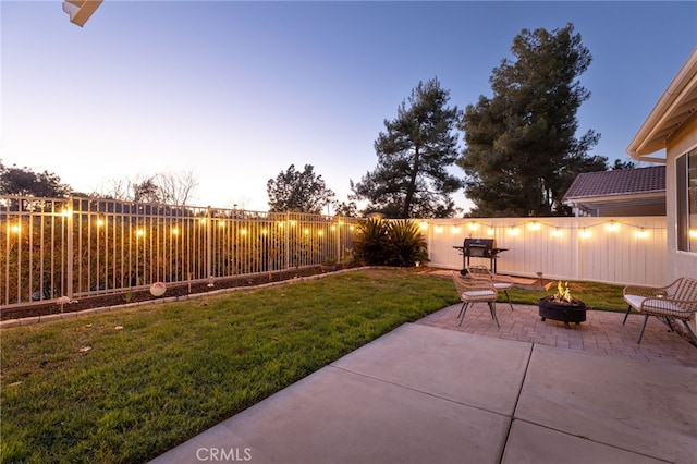 view of yard with a patio, a fenced backyard, and an outdoor fire pit