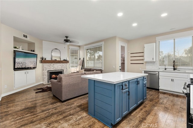 kitchen featuring visible vents, blue cabinetry, white cabinetry, and stainless steel appliances