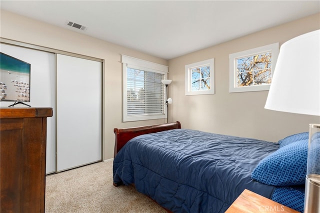 bedroom featuring visible vents, a closet, and carpet flooring