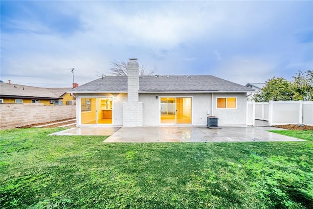 back of property with a yard, a fenced backyard, and a patio area