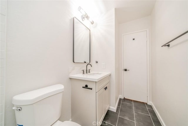 bathroom featuring vanity, tile patterned floors, toilet, and baseboards