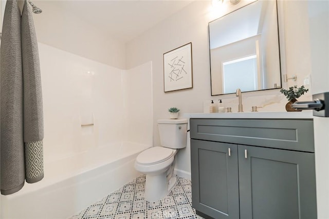 full bath featuring vanity, toilet, baseboards, and shower / washtub combination