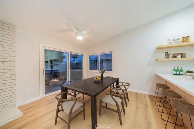 dining room with lofted ceiling, a ceiling fan, light wood-type flooring, and baseboards