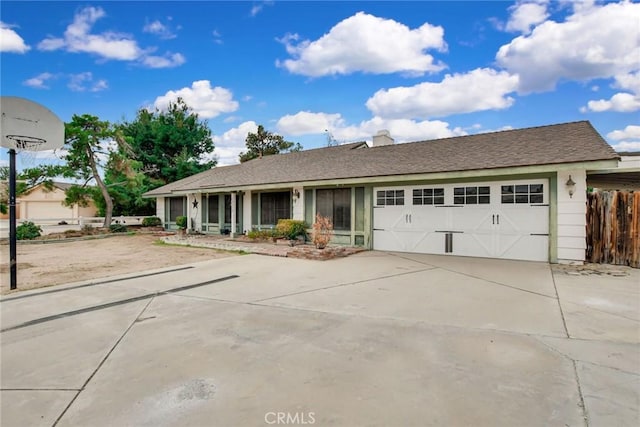 single story home with concrete driveway, a garage, and fence