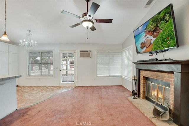 unfurnished living room with visible vents, a healthy amount of sunlight, a brick fireplace, carpet, and an AC wall unit