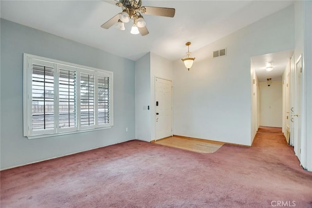 carpeted empty room featuring visible vents, ceiling fan, and vaulted ceiling