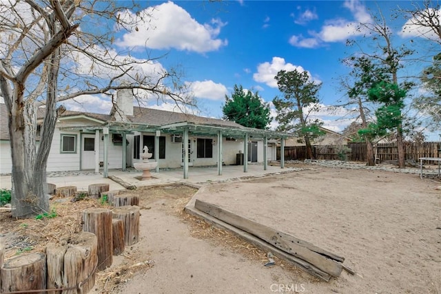 rear view of property featuring fence private yard, a chimney, and a patio area