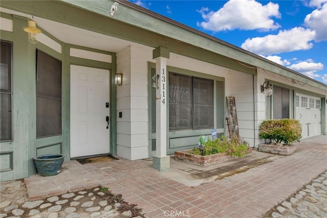 entrance to property with a garage and covered porch