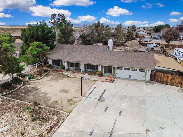 view of front of property featuring fence, a garage, driveway, and roof with shingles