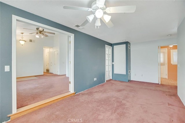 unfurnished bedroom with carpet flooring, a ceiling fan, and visible vents