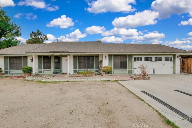 ranch-style home featuring roof with shingles, concrete driveway, and an attached garage