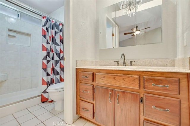 bathroom with vanity, tile patterned floors, toilet, and tiled shower