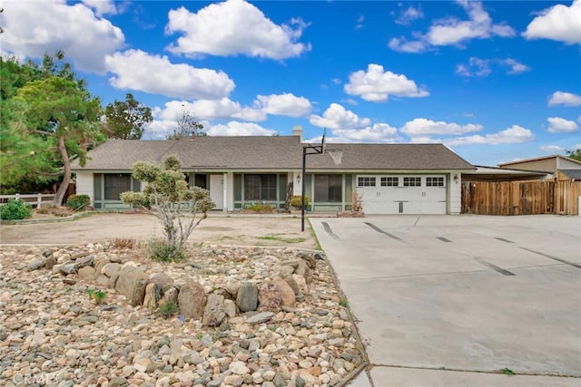 single story home featuring a garage, driveway, and fence