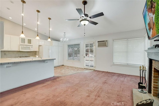 unfurnished living room with light carpet, an AC wall unit, ceiling fan with notable chandelier, lofted ceiling, and a brick fireplace