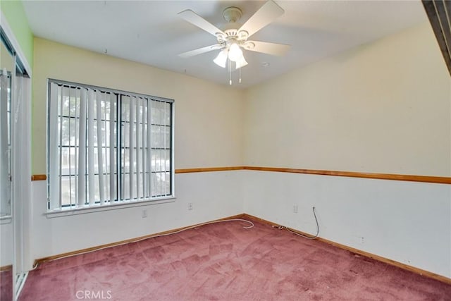 spare room featuring baseboards, carpet, and a ceiling fan