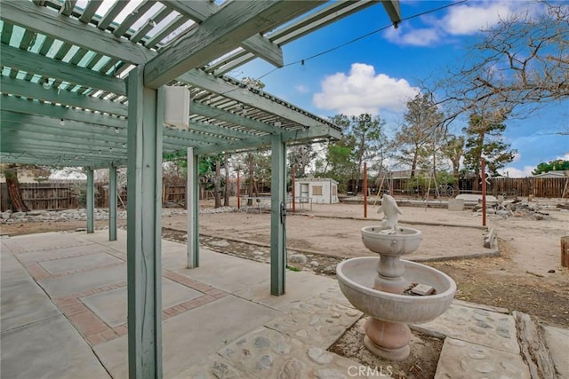 view of patio / terrace with an outdoor structure, a fenced backyard, a shed, and a pergola