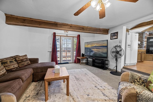 living area with beamed ceiling, light carpet, and a ceiling fan