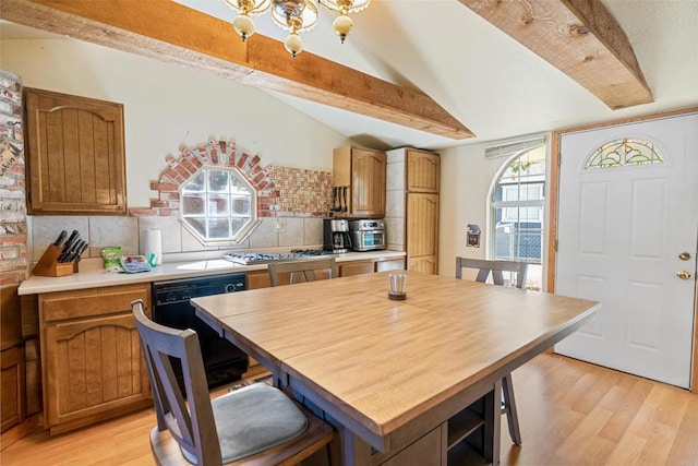 kitchen with backsplash, dishwasher, light wood-style flooring, and vaulted ceiling with beams