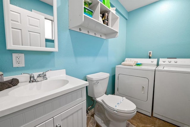 bathroom featuring washer and dryer, toilet, and vanity