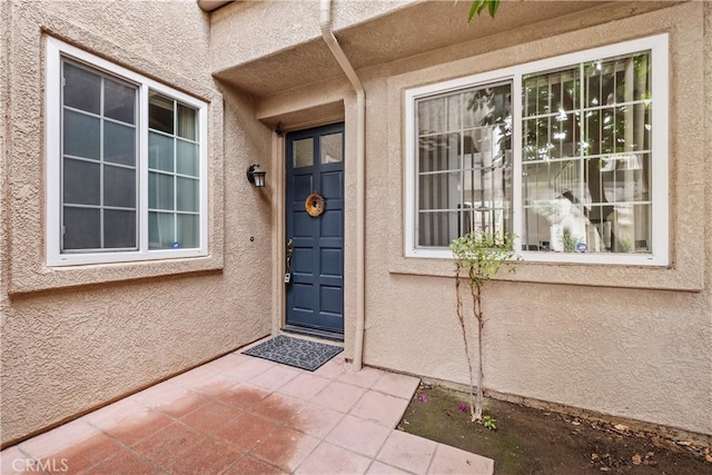 entrance to property featuring stucco siding