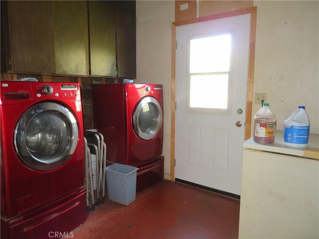 clothes washing area with cabinet space and separate washer and dryer