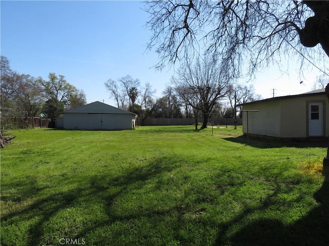 view of yard featuring an outdoor structure and fence