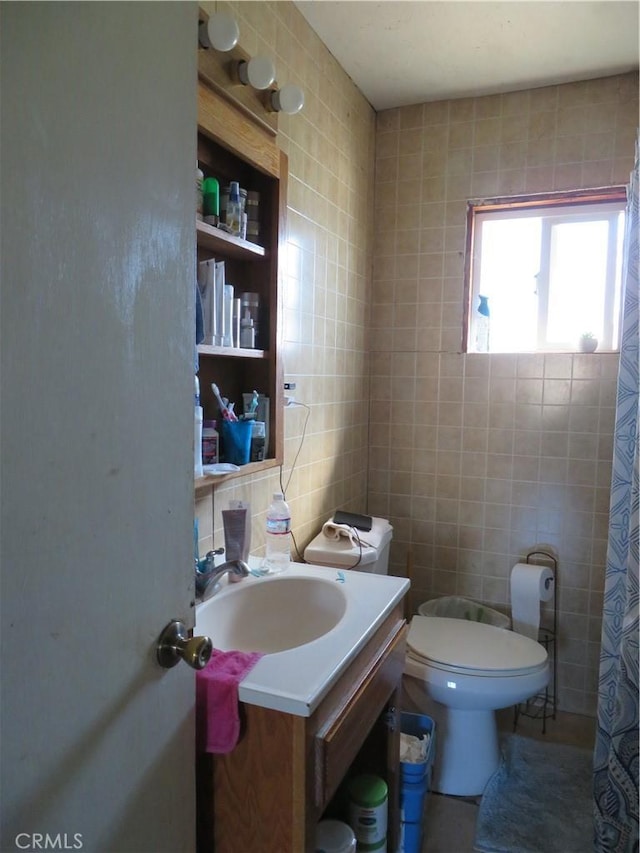 full bathroom with toilet, tile walls, and vanity