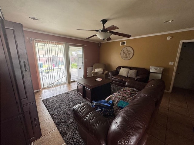 living room featuring light tile patterned flooring, visible vents, a ceiling fan, and ornamental molding