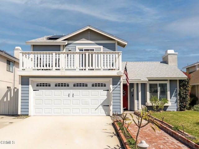 view of front of property featuring driveway, roof mounted solar panels, a shingled roof, a garage, and a chimney