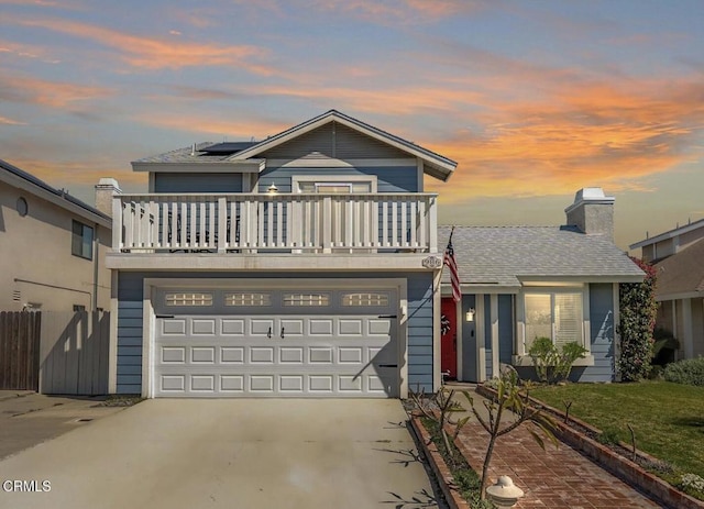 traditional home with fence, concrete driveway, roof mounted solar panels, a yard, and an attached garage